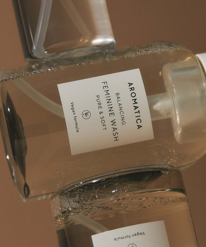 AROMATICA Pure & Soft Balancing Feminine Wash de la marque AROMATICA, flacon en verre sur fond beige, contexte photo.