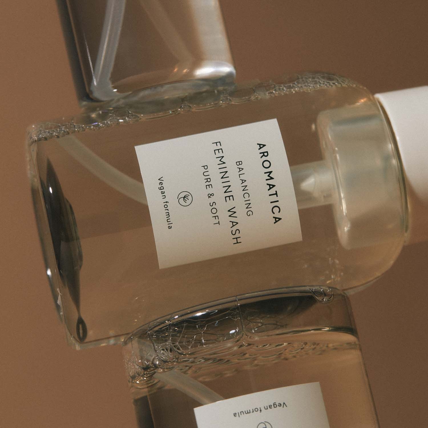AROMATICA Pure & Soft Balancing Feminine Wash de la marque AROMATICA, flacon en verre sur fond beige, contexte photo.