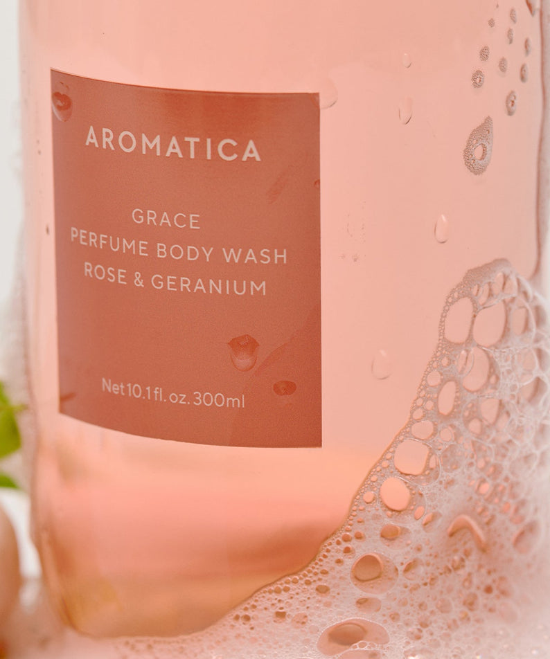 AROMATICA Grace Perfume Body Lotion Rose & Geranium 300ML, flacon rose sur fond clair, gouttes d’eau visibles, détail étiquette.
