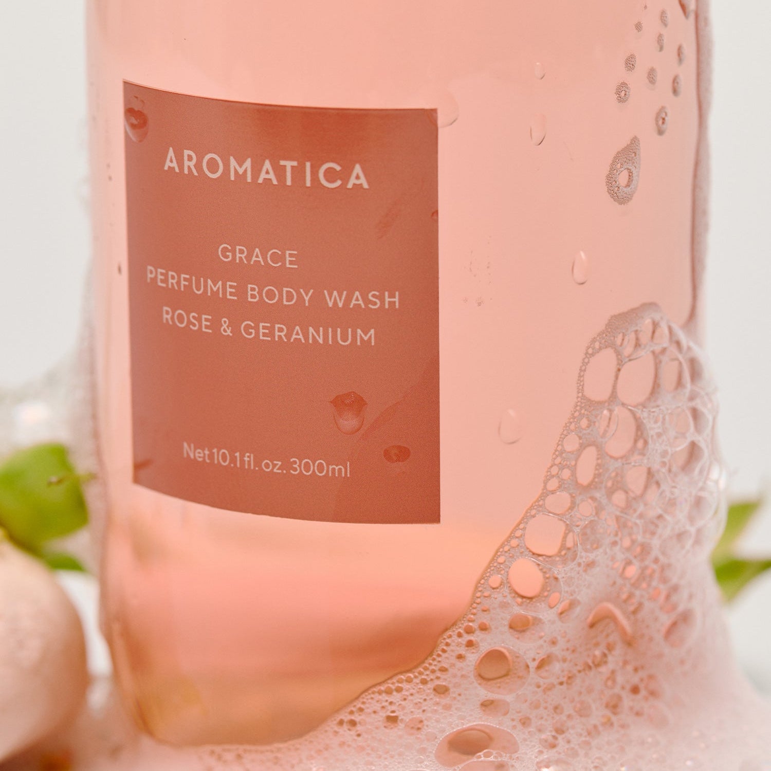 AROMATICA Grace Perfume Body Lotion Rose & Geranium 300ML, flacon rose sur fond clair, gouttes d’eau visibles, détail étiquette.