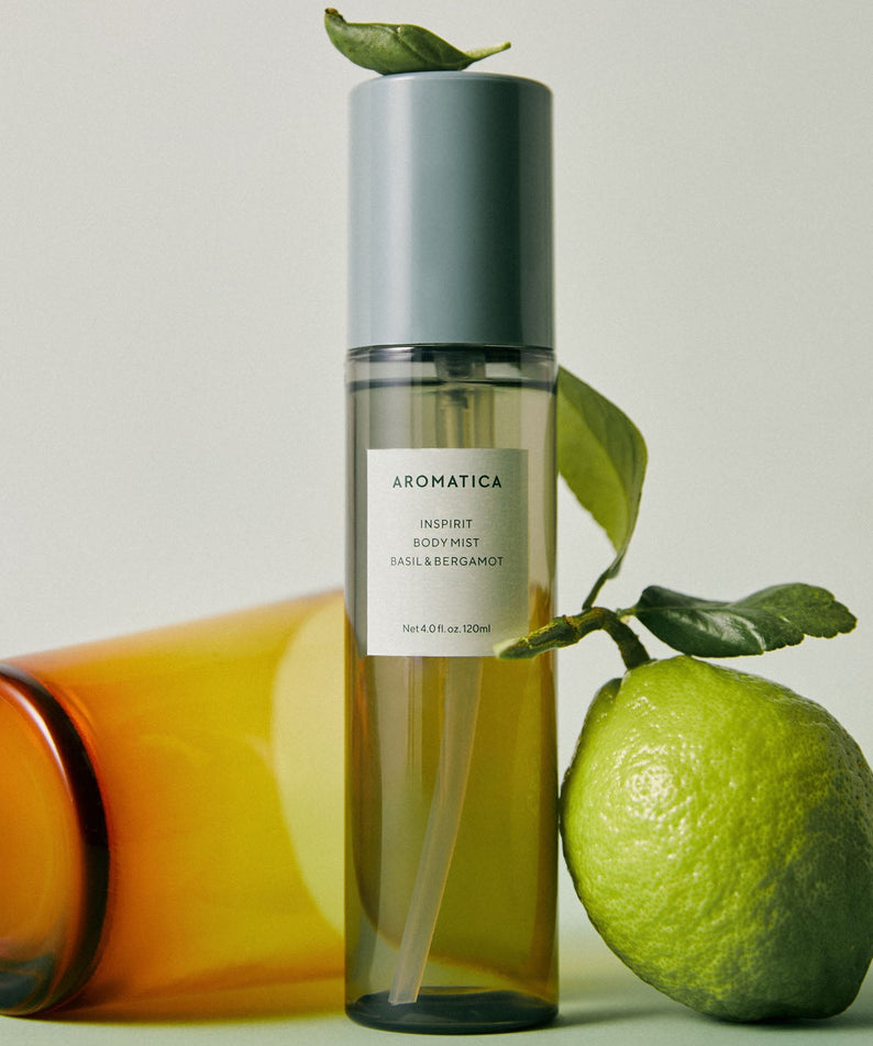 Décris l’image en français : AROMATICA Inspirit Body Mist Basil & Bergamot 120ML, flacon sur fond clair avec basilic et citron.