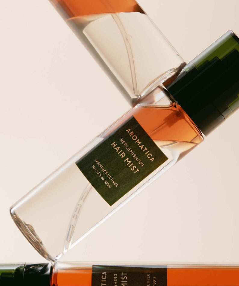 AROMATICA Replenishing Hair Mist Jasmine & Vetiver 100ml, brume pour cheveux, flacon vert et verre sur fond beige