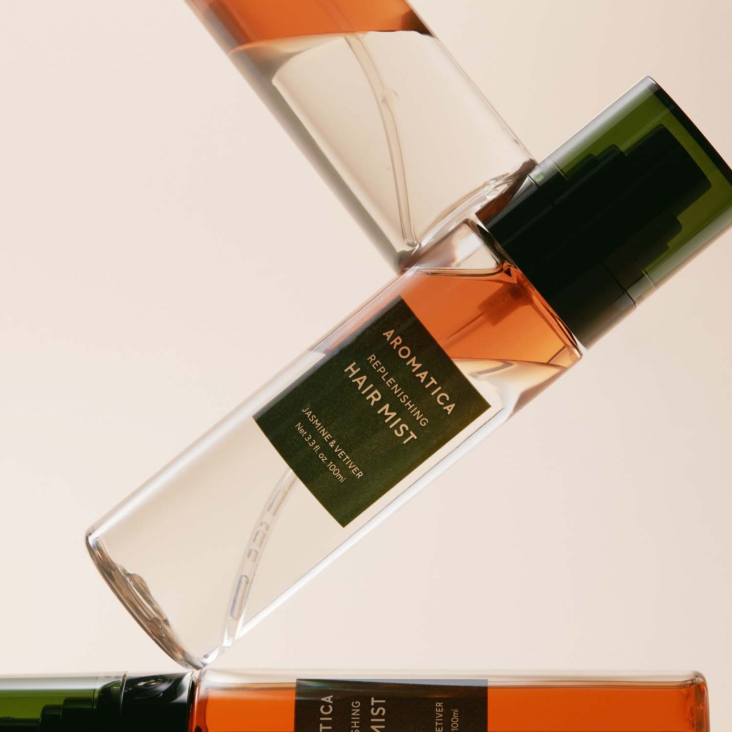 AROMATICA Replenishing Hair Mist Jasmine & Vetiver 100ml, brume pour cheveux, flacon vert et verre sur fond beige