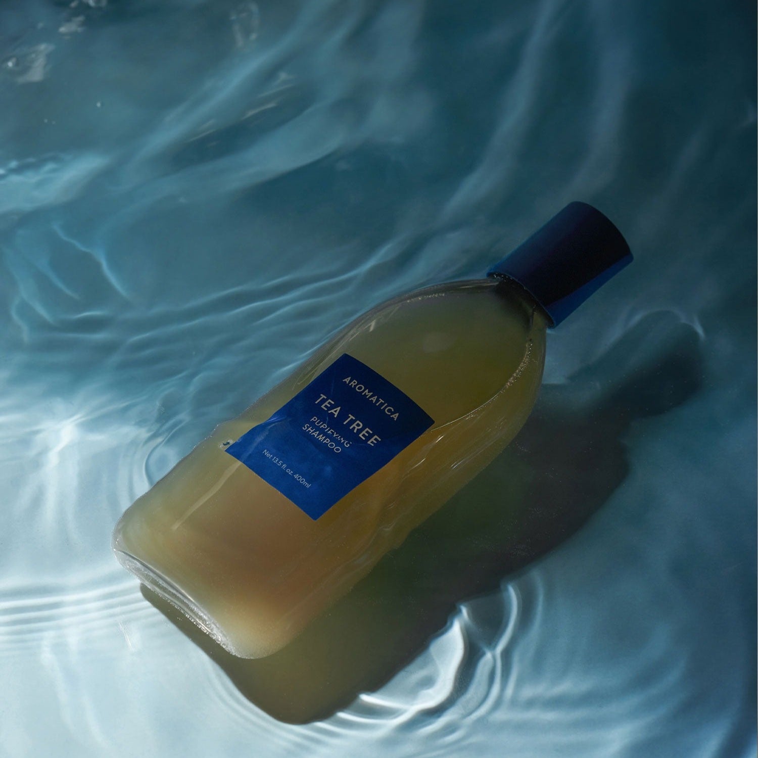 Décris l'image en français en mentionnant le produit, la marque et le contexte visuel. AROMATICA Tea Tree Purifying Shampoo 750ML