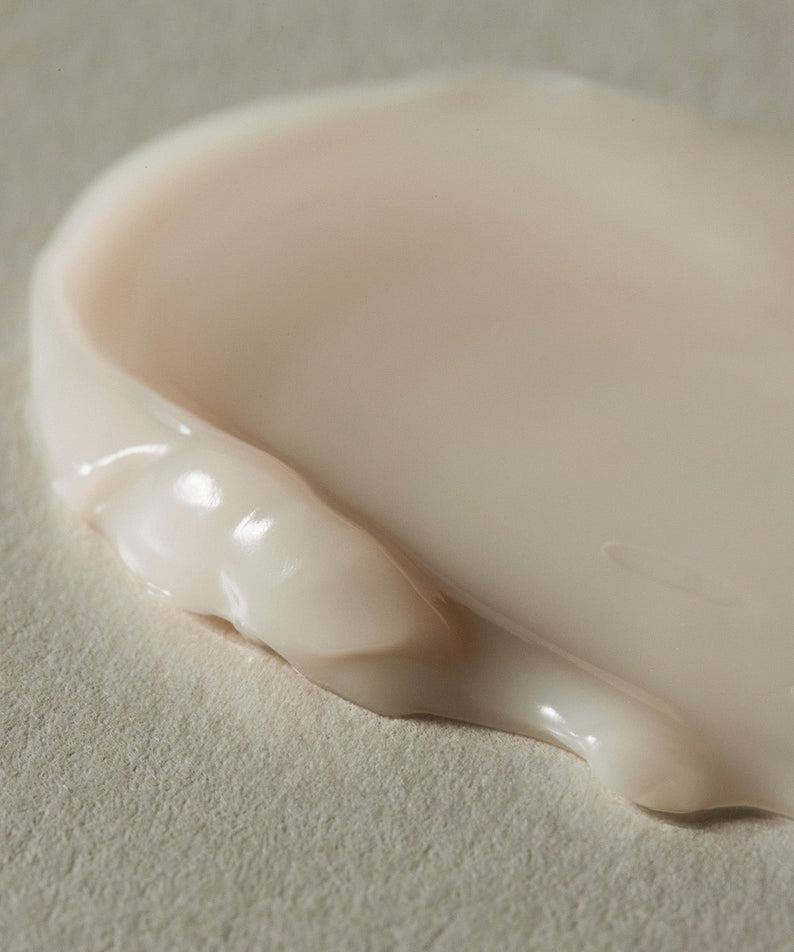 Texture de la crème AROMATICA Vitalizing Rosemary Firming Cream 50ML sur une surface, gros plan.