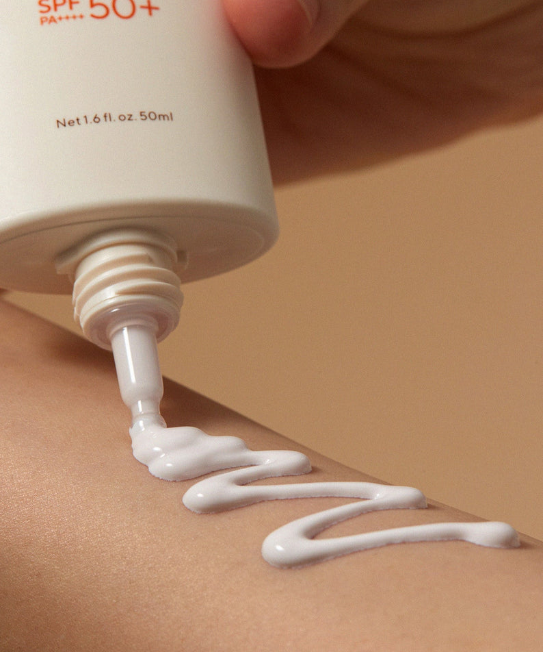 AROMATICA Vitalizing Rosemary Moisture Barrier Sunscreen 50ML, tube SPF50+ déposant une crème sur peau, gros plan.