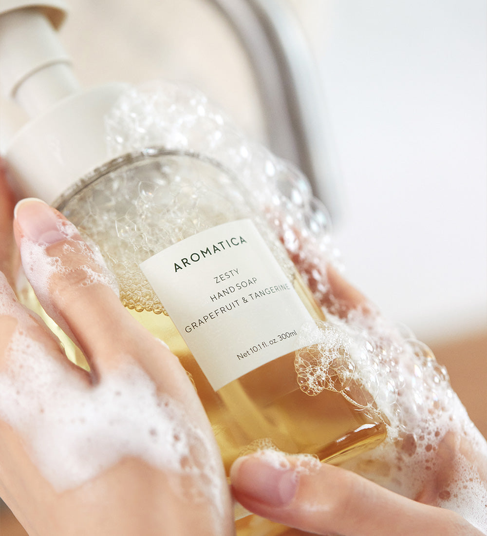 AROMATICA Zesty Hand Soap Grapefruit & Tangerine 300ML, marque sur flacon en mains sous mousse, salle de bain