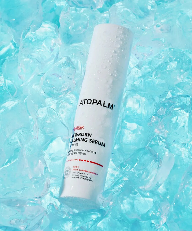 Décris l'image en français en mentionnant le produit, la marque et le contexte visuel : ATOPALM Newborn Calming Serum 50ml sur glace bleue.