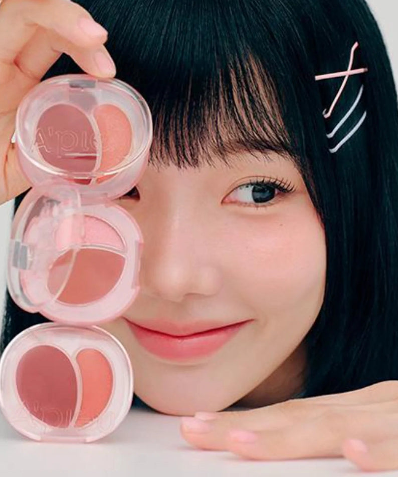 Femme souriante avec A'PIEU Juicy Pang Mood Blending Lip & Cheek Balm, baume à lèvres et joues, maquillage coréen incontournable.