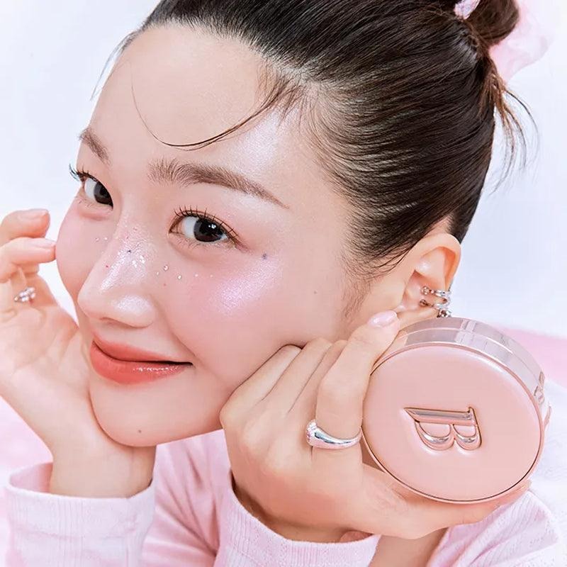 BANILA CO Essence Skin Pink Cushion de Banila Co, sur un visage maquillé, éponge/poudre rose en contexte beauté.