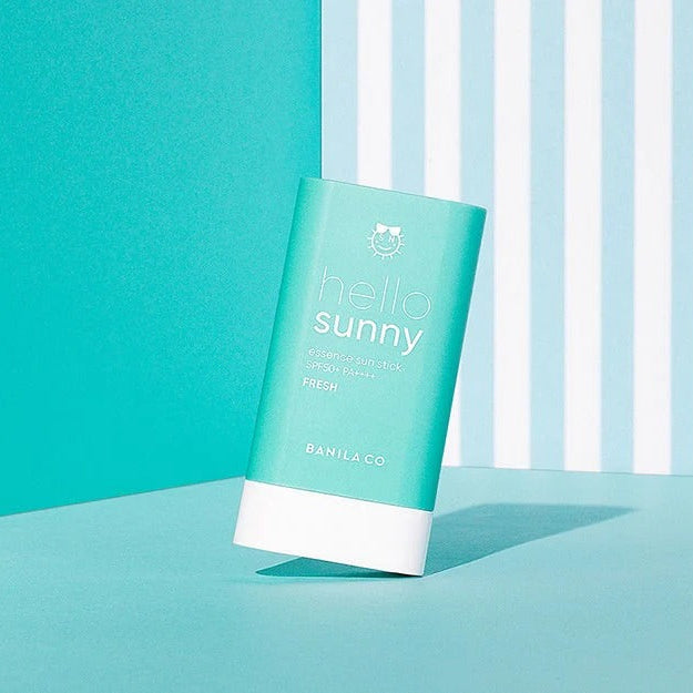 BANILA CO Hello Sunny Essence Sun Stick Fresh SPF50+PA++++ sur fond turquoise, packaging Hello Sunny, crème solaire en stick