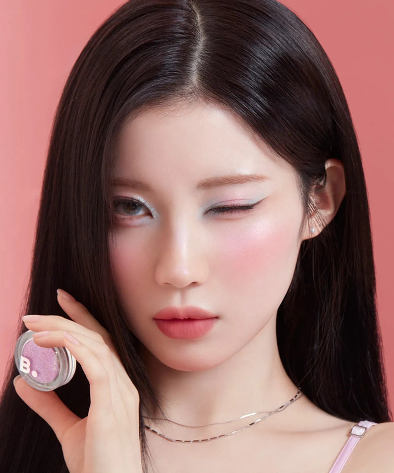 BANILA CO Hyper Holobeam Eye Glitter de BANILACO, maquillage yeux scintillant sur fond rose, maquillée de près.