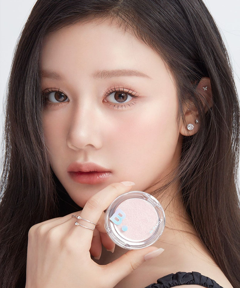 BANILA CO Silky Glow Highlighter, gros plan sur visage maquillé et poudre highlighter argentée, fond clair, marque Banila Co.