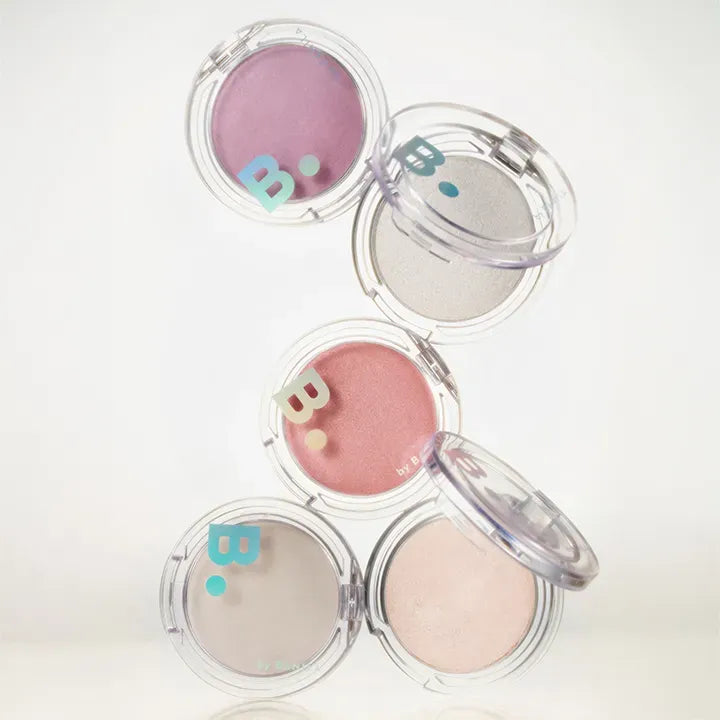 BANILA CO Silky Glow Highlighter de BANILACO : poudres nacrées en coupelles transparentes sur fond clair, rendu maquillage.