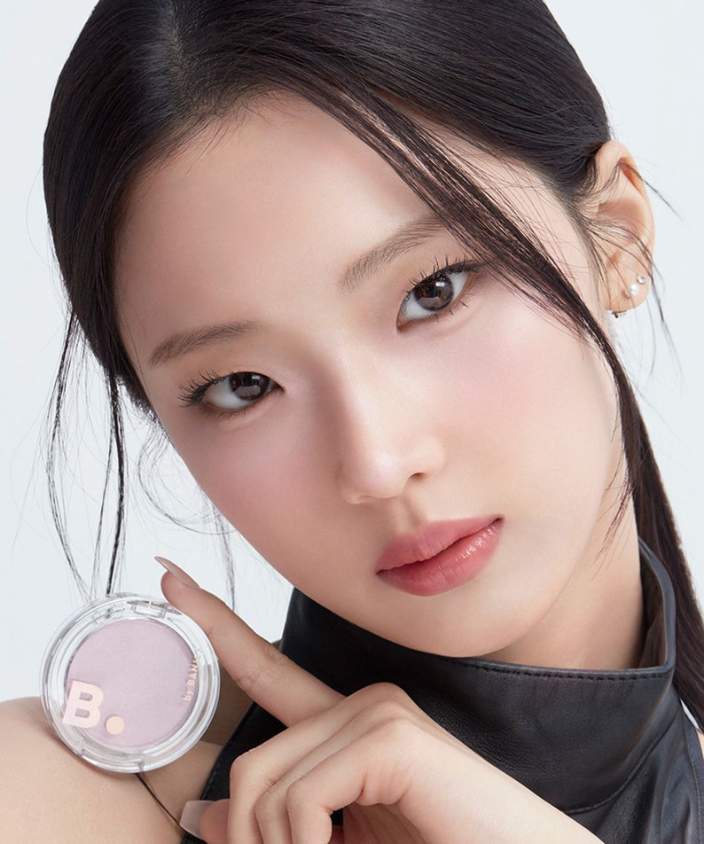 Femme démontrant le BANILACO Silky Glow Highlighter pour un teint éclatant et lumineux. Maquillage illuminateur en vedette.