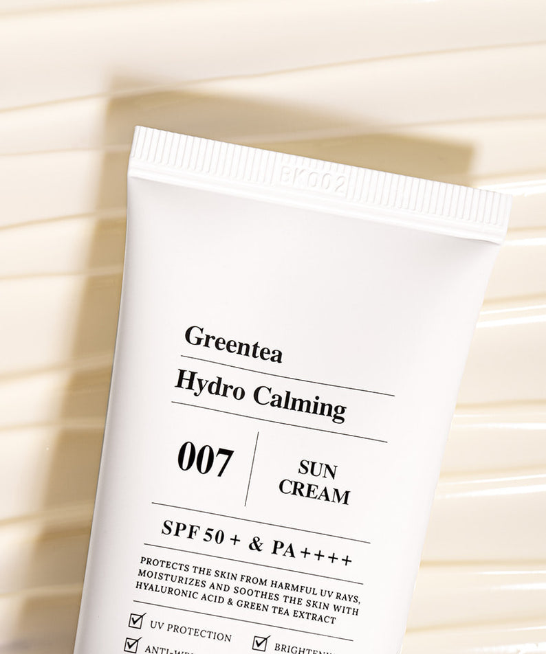 Crème solaire BARULAB Green Tea Hydro Calming Sun Cream sur surface texturée beige, SPF 50+ pour une peau hydratée et protégée.