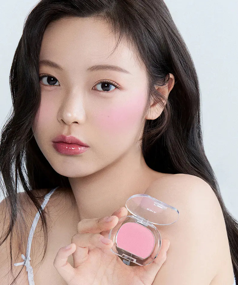BBIA  Pia Last Blush 15 Colors, portrait maquillage sur fond clair, boîte de blush rose en main de la modèle