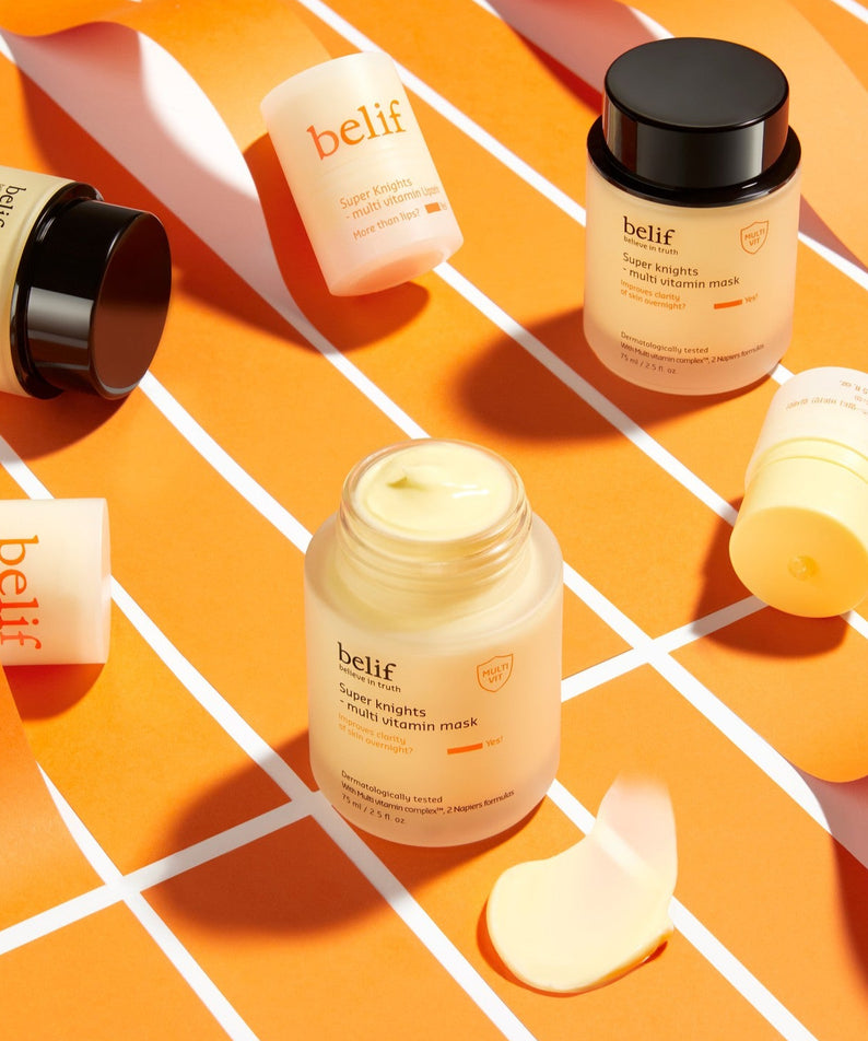 Produits de soin BELIF Super Knights Multi Vitamin Mask 75ml exposés sur fond orange, masque hydratant multi-vitaminé.