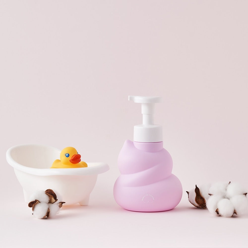 BELLBOY STUDIO Hippong Bubble Butt Cleanser sur fond pastel, flacon rose avec canard en caoutchouc et coton.