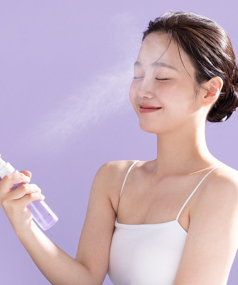 Décris l'image en français : BENTON Guava Hydrating Collagen Mist 100ml, bouteille et brume sur une femme en photo spa.
