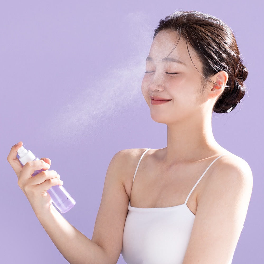 Décris l'image en français : BENTON Guava Hydrating Collagen Mist 100ml, bouteille et brume sur une femme en photo spa.