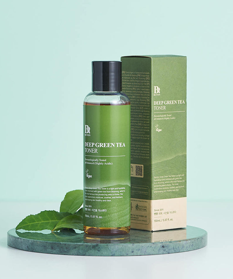 BENTON Deep Green Tea Toner 150ml : toner vert sur socle avec feuilles de thé, pack BENTON en arrière-plan sur fond clair.