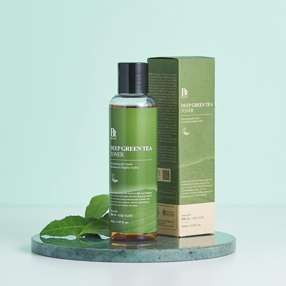 BENTON Deep Green Tea Toner 150ml : toner vert sur socle avec feuilles de thé, pack BENTON en arrière-plan sur fond clair.