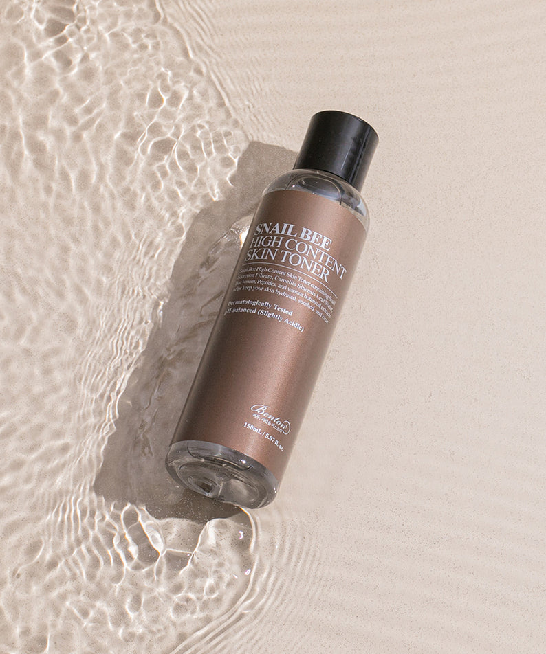 BENTON Snail Bee High Content Skin Toner 150ml, flacon sur fond beige avec texture eau et bulles, ambiance skincare.