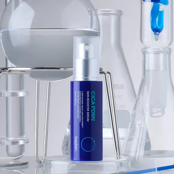 BEPLAIN Cica PDRN Skin Booster Serum 30ml, flacon bleu au milieu d’un décor de laboratoire cosmétique