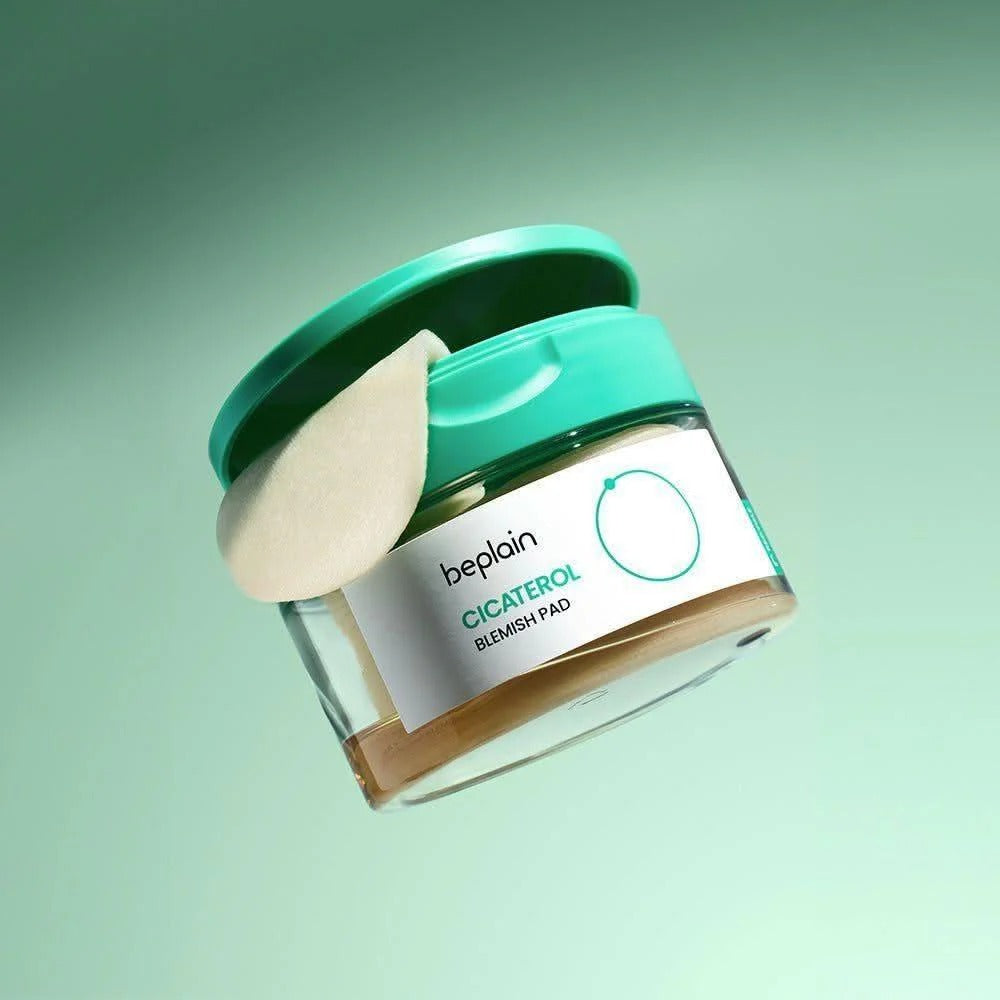 BEPLAIN Cicaterol Blemish Pad 80 sheets, coussinets anti-imperfections à l’aspect blanc, flacon vert sur fond vert pastel.