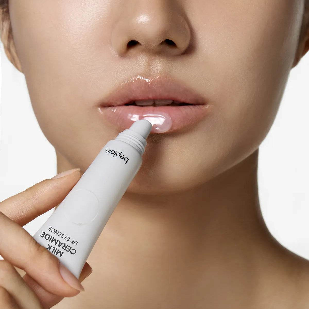 BEPLAIN Milk Ceramide Lip Essence 10g, femme applique un soin lèvres en gros plan sur fond clair