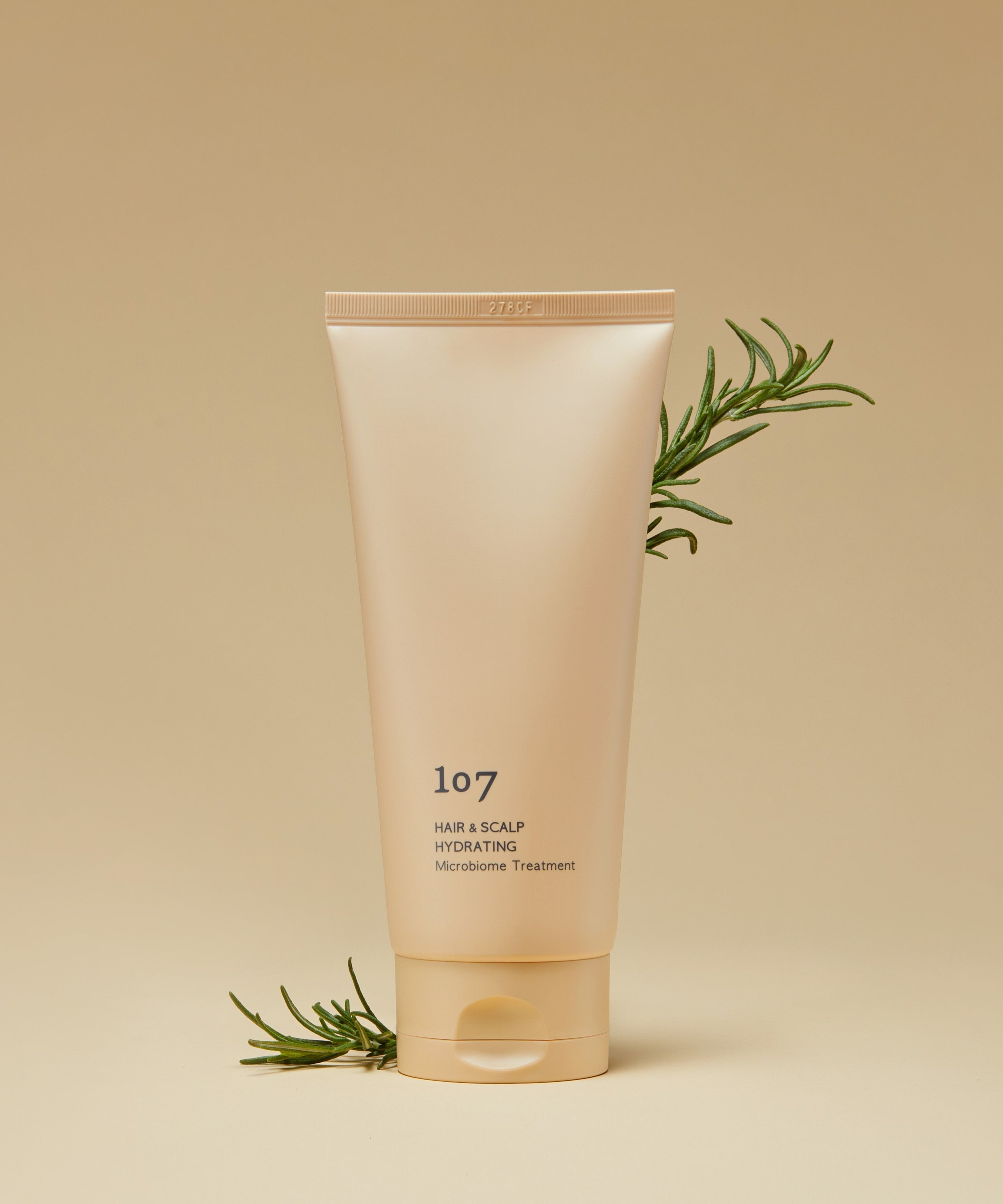 107 Hair & Scalp Hydrating Microbiome Treatment 180ml de la marque 107, tube crème sur fond beige avec herbes
