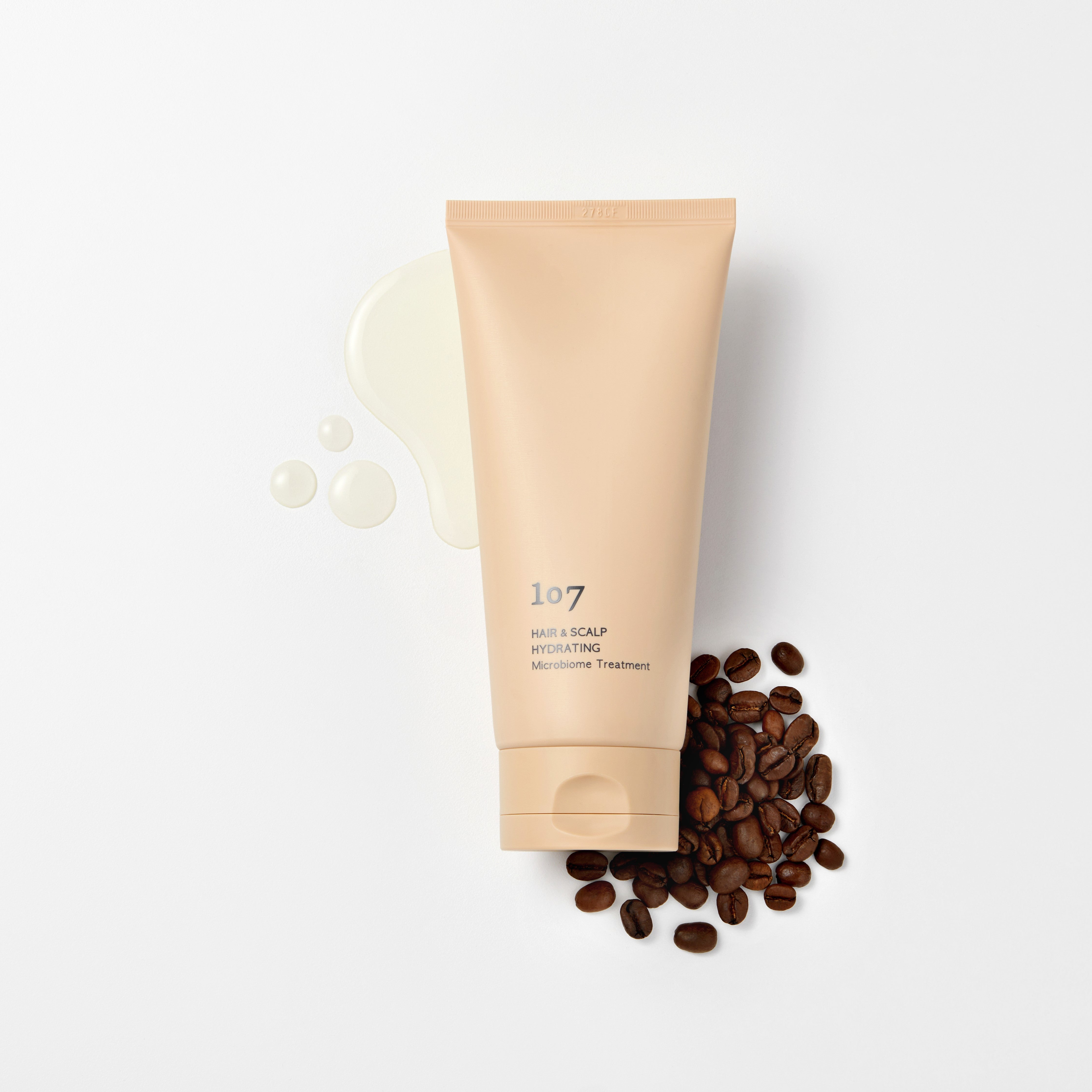 107 Hair & Scalp Hydrating Microbiome Treatment 180ml de 107, tube beige sur fond clair avec grains de café
