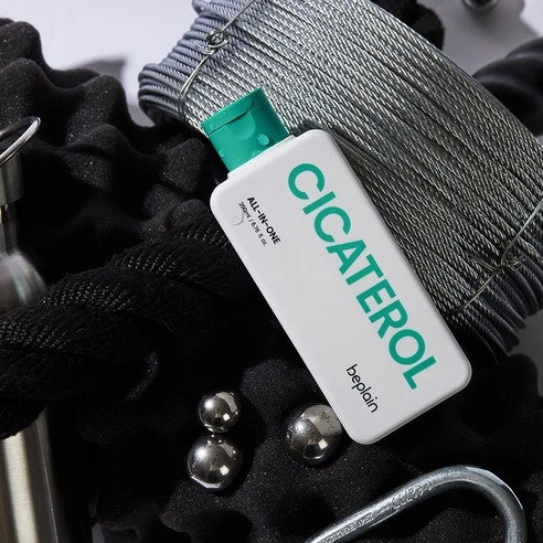 BEPLAIN Cicaterol All-in-one : étiquette produit sur élastique gris et textile noir, accessoires de soin en contexte visuel.