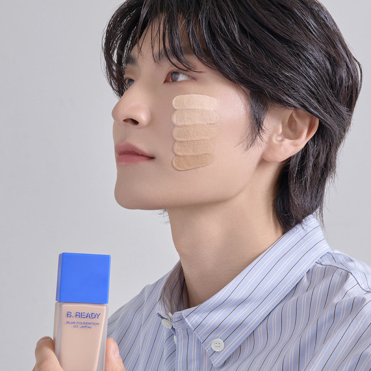 B.READY Blue Foundation SPF27/PA++ 35ml de BE.READY, flacon bleu, maquillage SPF sur modèle visage, fond clair.