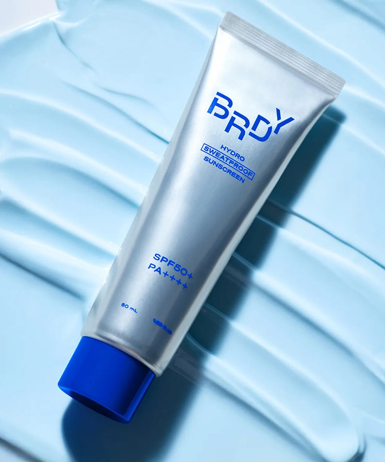 B.READY Hydro Sweatproof Sunscreen 50ml de la marque B.READY sur fond bleu, texture crème et contexte visuel solaire