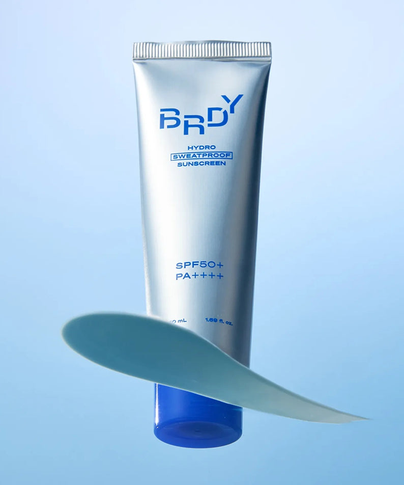 B.READY Hydro Sweatproof Sunscreen 50ml de la marque B.READY, tube bleu sur fond bleu, contexte produit en extérieur.