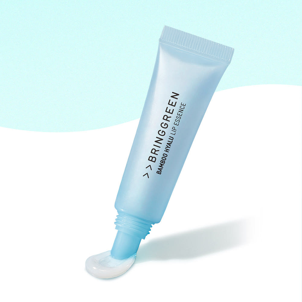 BRINGGREEN Bamboo Hyalu Lip Essence, tube cosmétique sur fond bleu clair, marque visible en gros plan.