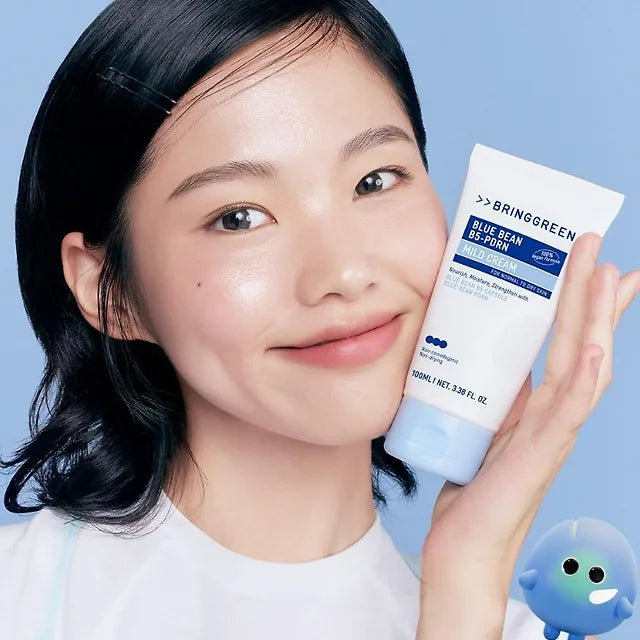 BRINGGREEN Blue Bean B5-PDRN Mild Cream 100ml, crème douce, marque BRINGGREEN, femme tenant le tube sur fond bleu.