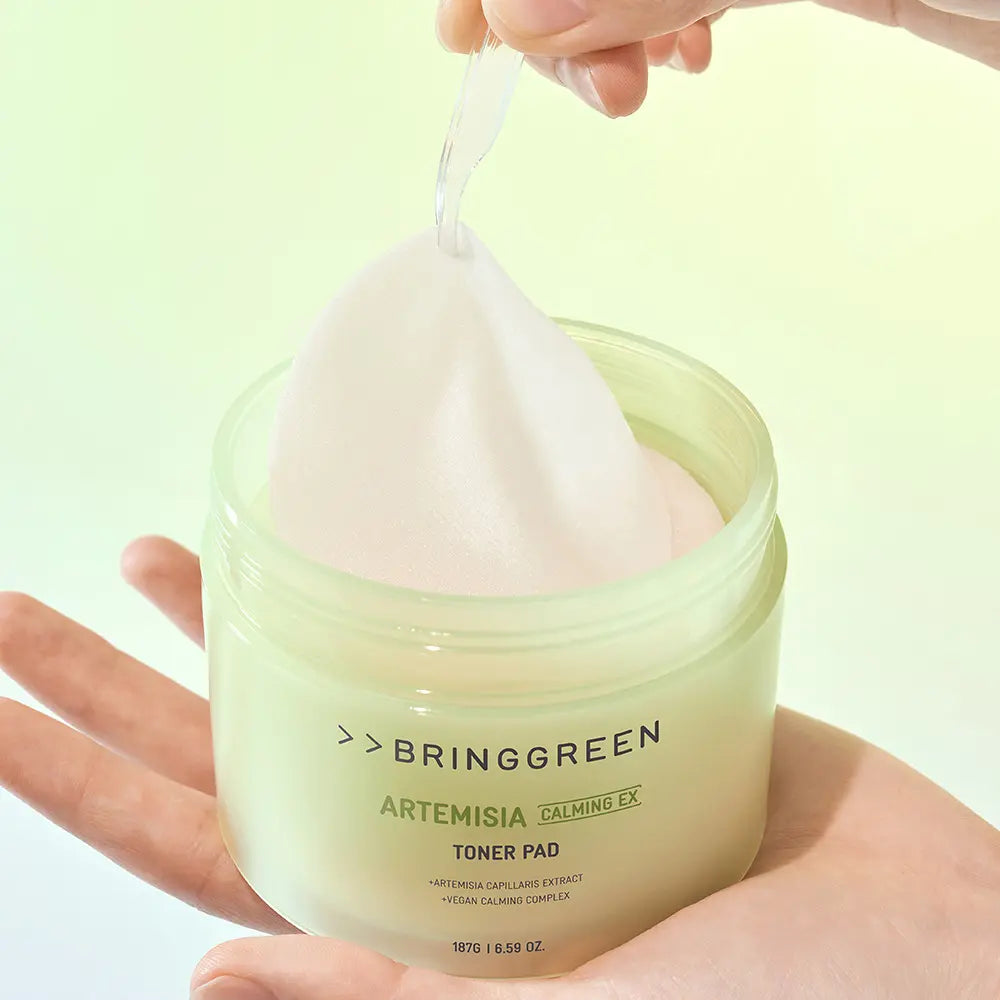 BRINGGREEN Mugwort Calming EX Toner Pads 75 Sheets, mains tenant des pads à base d’armoise, pot vert sur fond clair