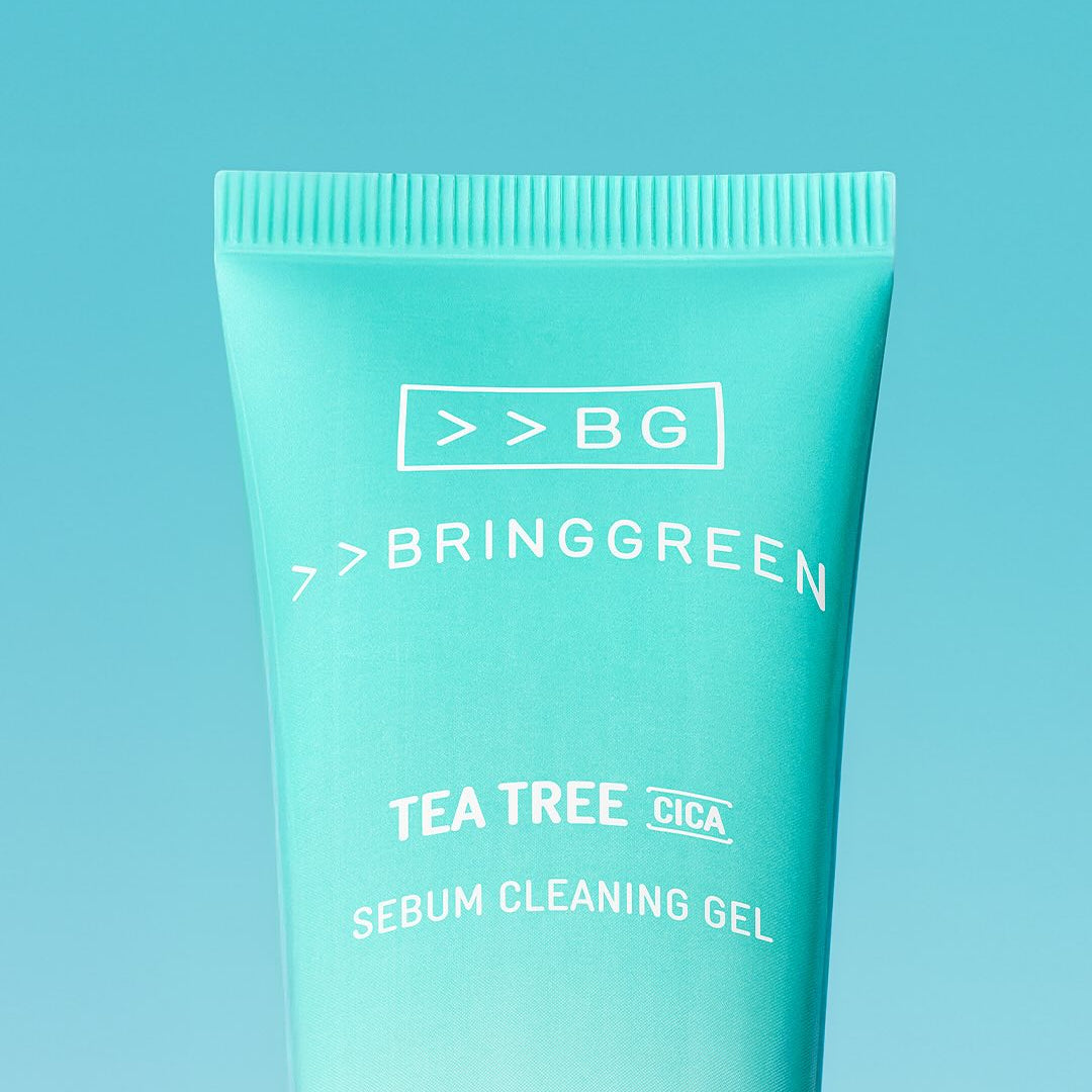 Décris l'image en français : BRINGGREEN Tea Tree Cica Sebum Cleansing Gel 50ml, tube vert sur fond bleu.