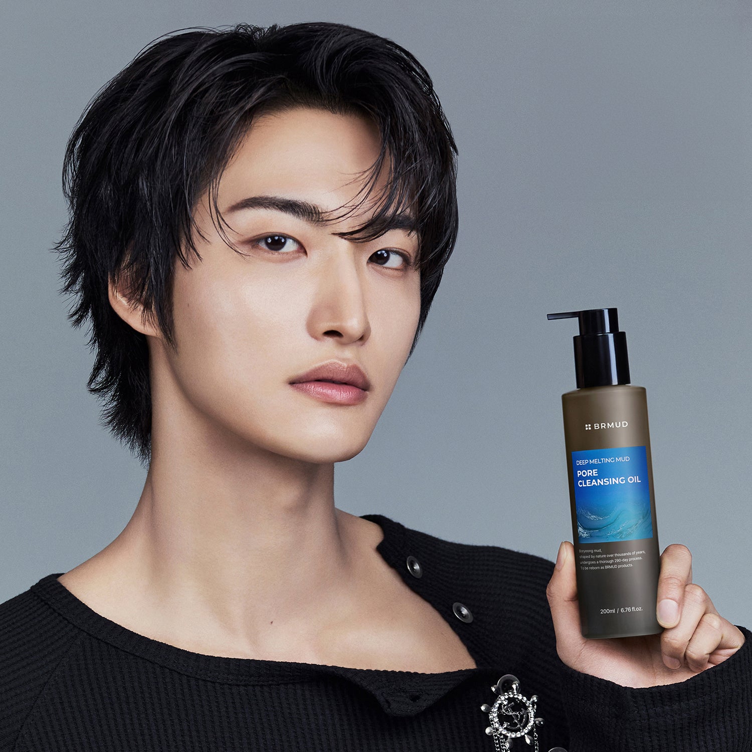 BRMUD Deep melting Mud Pore Cleansing Oil 200ML, huile démaquillante en flacon noir, main en tenue, modèle visage.