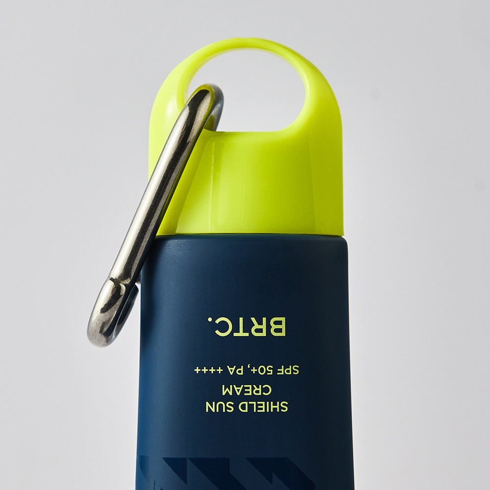 BRTC Homme Active Max Sheild Sunscreen 50ml, tube vert et bleu, contexte visage homme, marque BRTC sur fond clair.