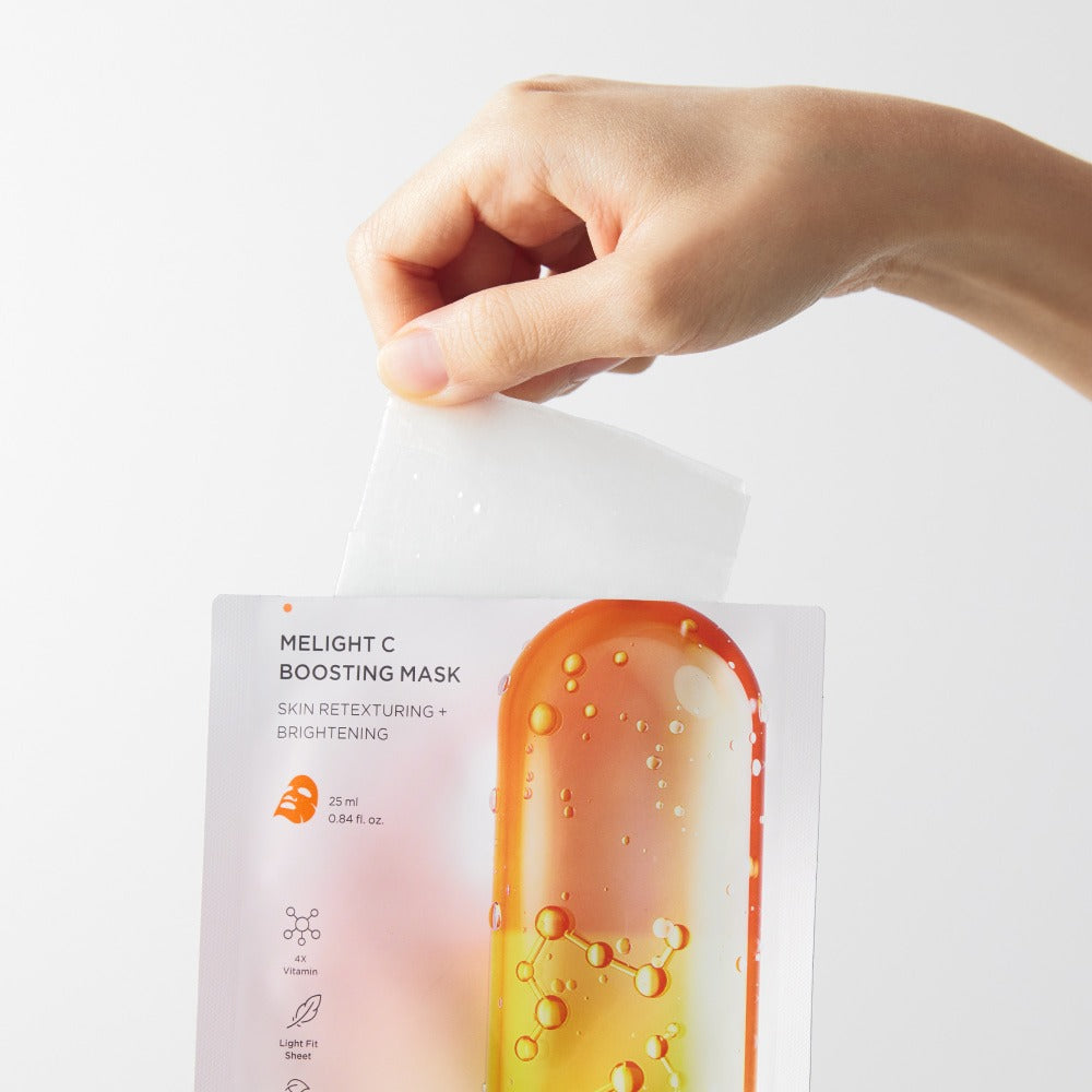 Décris l'image en français : BRTC Melight C Boosting Mask 10 Sheets, la main tient un masque en film, fond blanc.