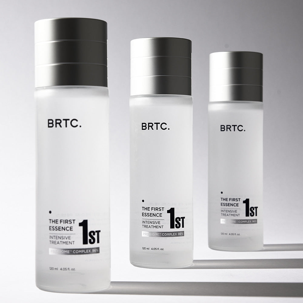 BRTC The First Essence 120ml : flacon blanc BRTC avec étiquette 1st, sur fond clair, présentoir cosmétique.