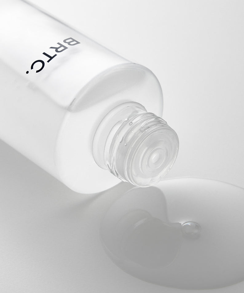 BRTC The First Essence 120ml, flacon blanc de sérum cosmétique avec texture fluide, fond clair minimaliste