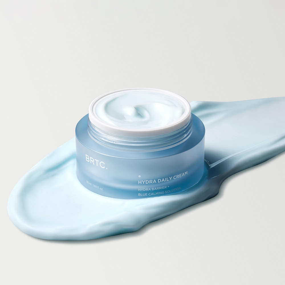 BRTC Hydra Daily Cream 50ml : crème hydratante BRTC sur fond clair, dans une touche de tissu bleu, visuel produit.