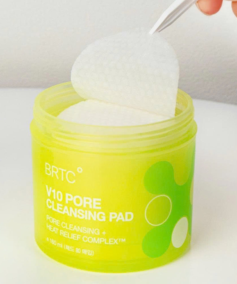 BRTC V10 Pore Cleansing Pad 80p 165ml : boîtier vert avec disque blanc ouvert, main tenant l’accessoire, salle de bain