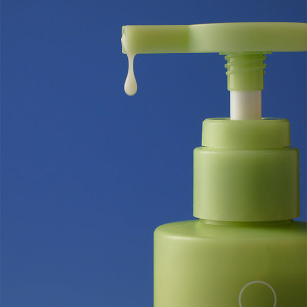 BY WISHTREND Green Tea & Enzyme Milky Foaming Wash 140ml, flacon vert sur fond bleu, mousse sort du distributeur