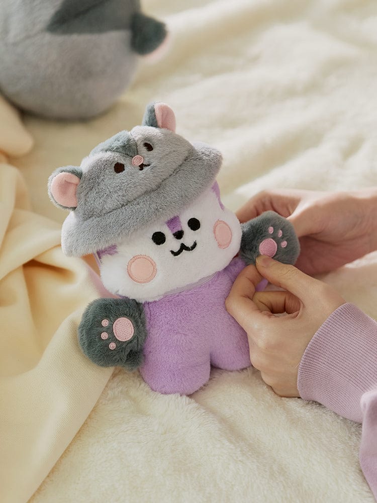 BT21 BABY COSTUME PLUSH CLOSET - FLYING SQUIRREL FLUFFY en peluche bébé, sur lit, personnage gris violet, mains qui touchent.